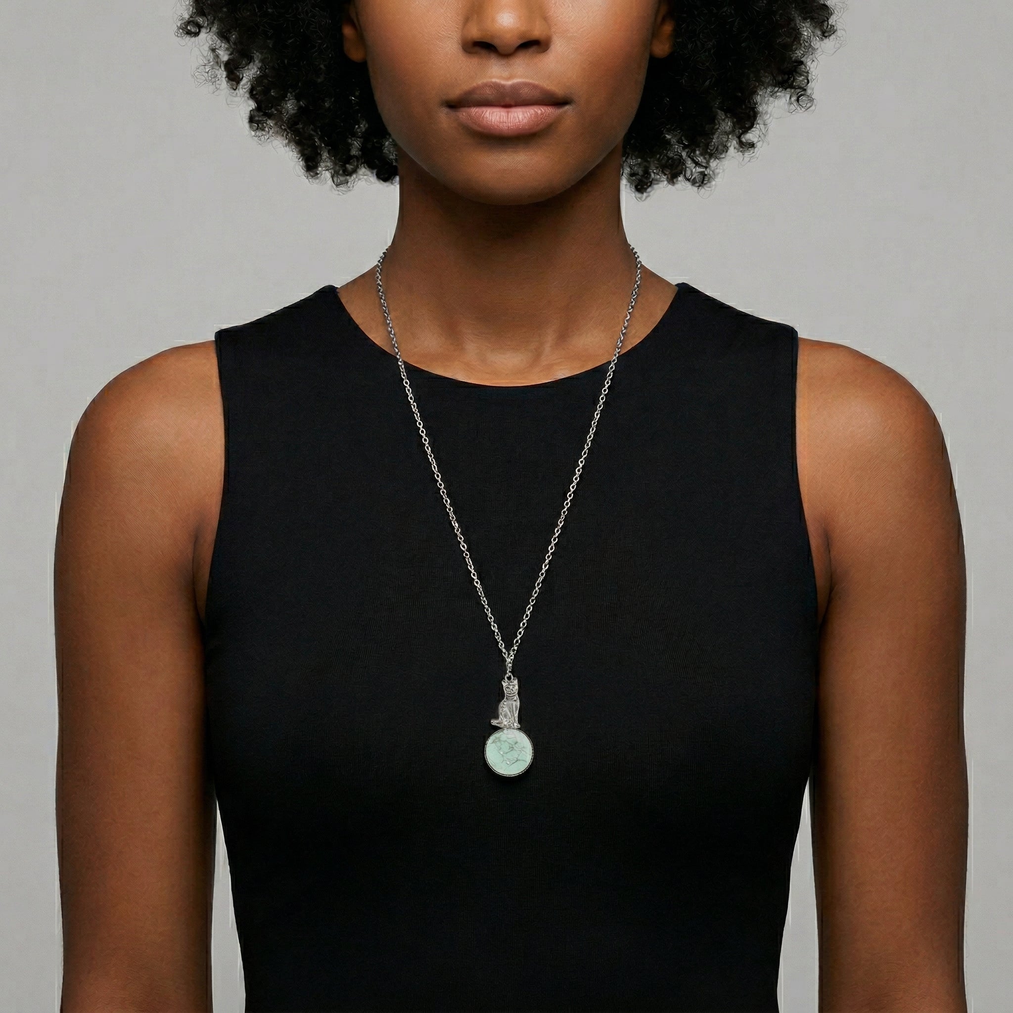 Woman wearing a black sleeveless top with a Sitting Cat On Round Turquoise Gemstone Pendant Necklace
