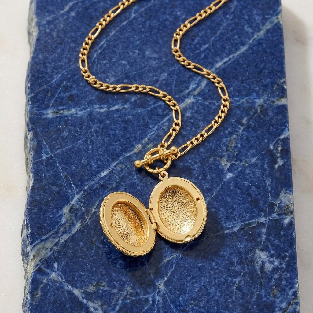 Oval Crystal Filigree Double Locket Necklace on a blue marble surface