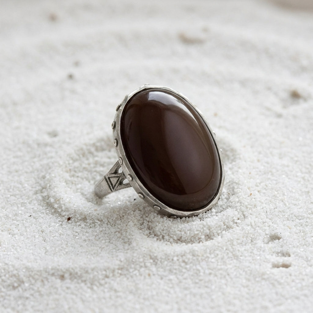 Carnelian Gemstone Austrian Crystal Oval Ring resting on fine white sand