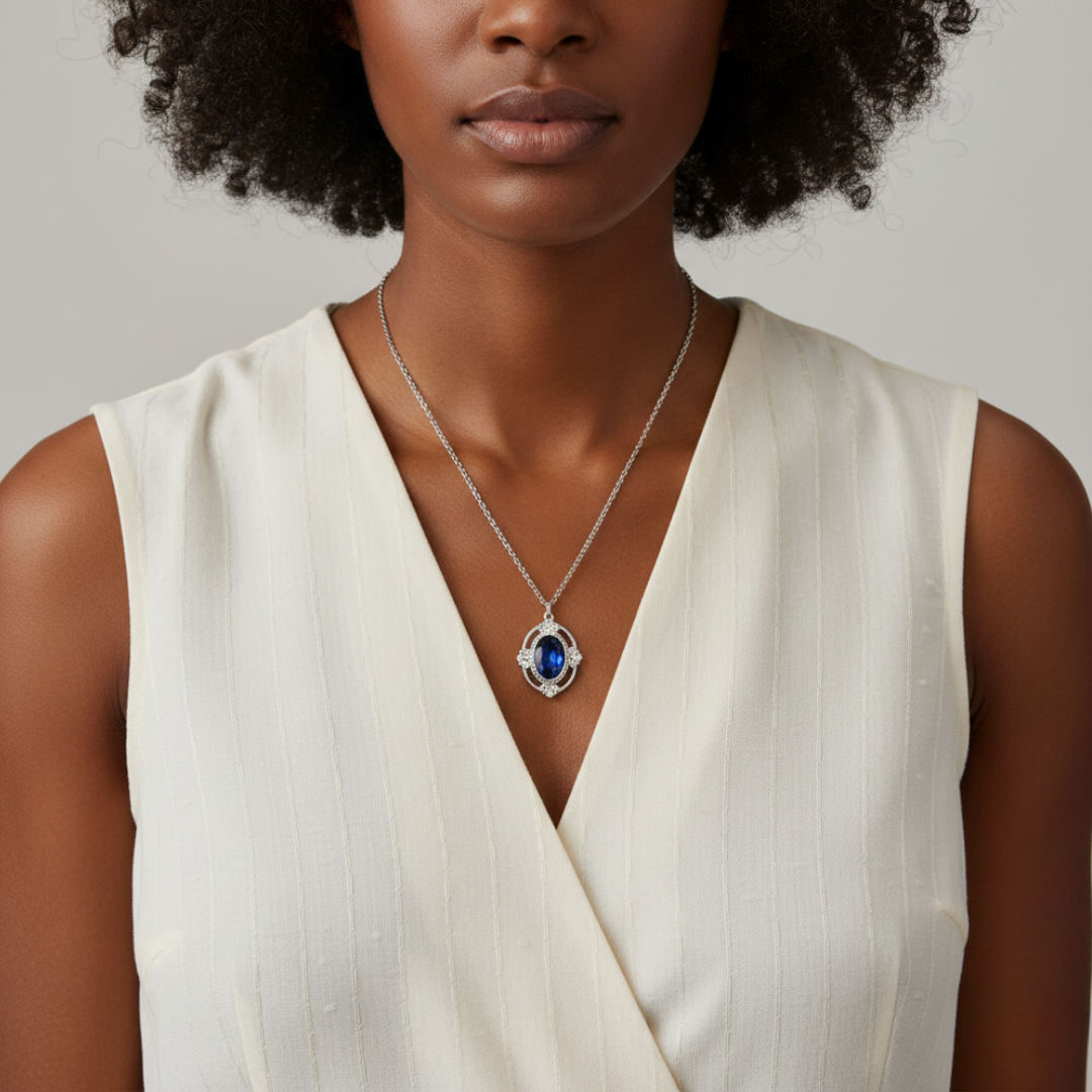 Woman wearing a white sleeveless top and a necklace with a blue pendant on a neutral background