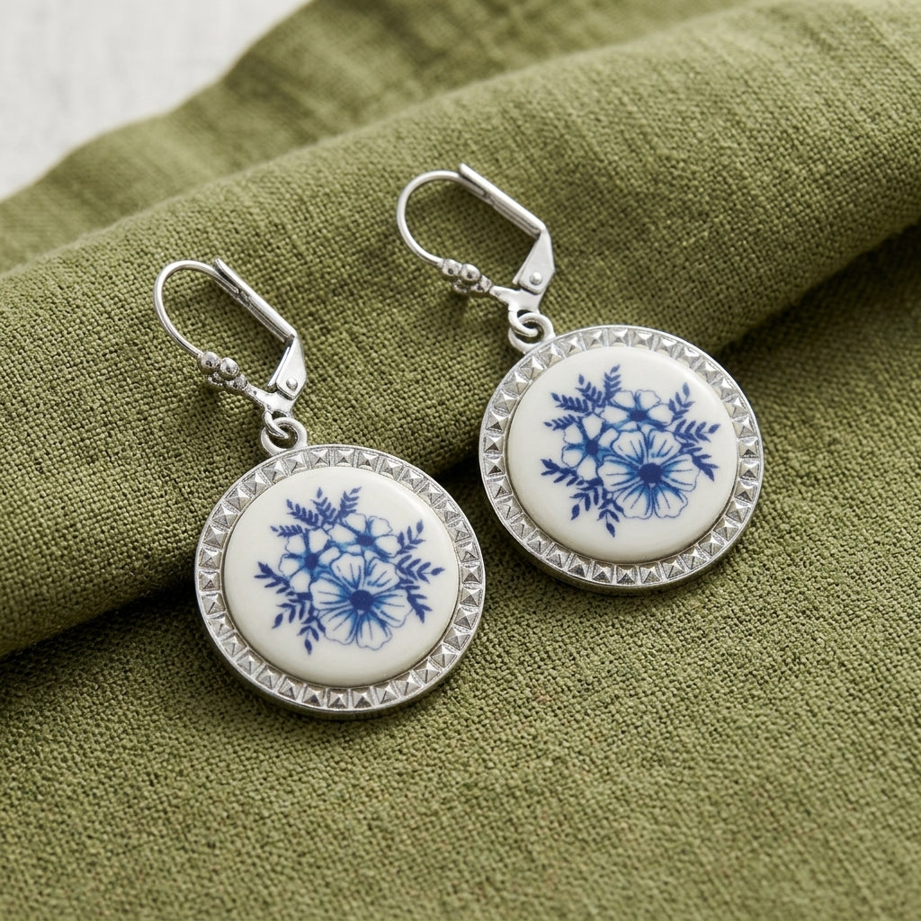Round Blue Willow earrings with lever back closures resting on olive green linen