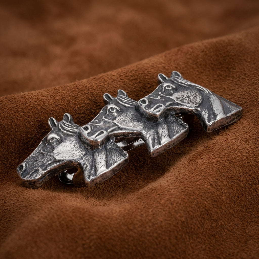 Small Antiqued Horse Herd Hair Barrette on a brown fabric background