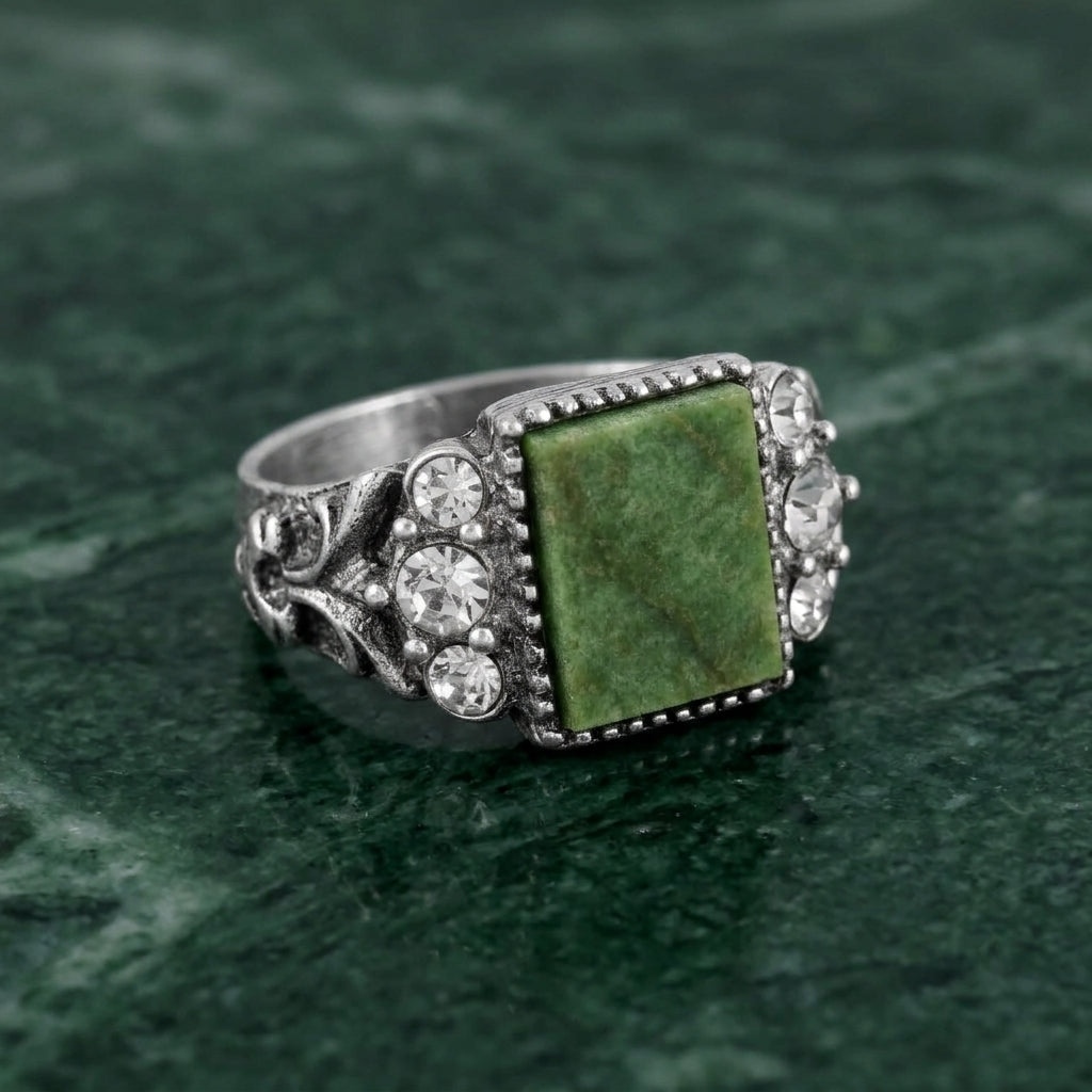 Jade Gemstone Crystal Accent Ring on a green stone textured background