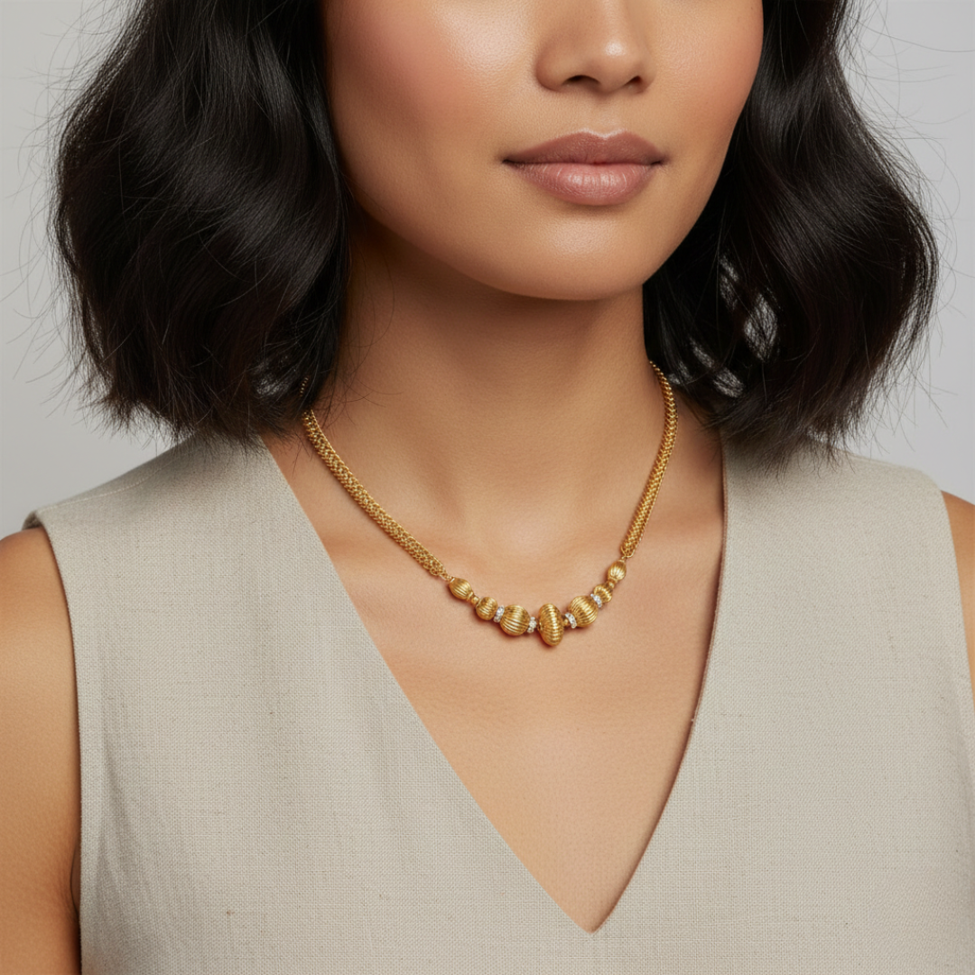 Woman wearing a gold-dipped beaded necklace against a neutral background