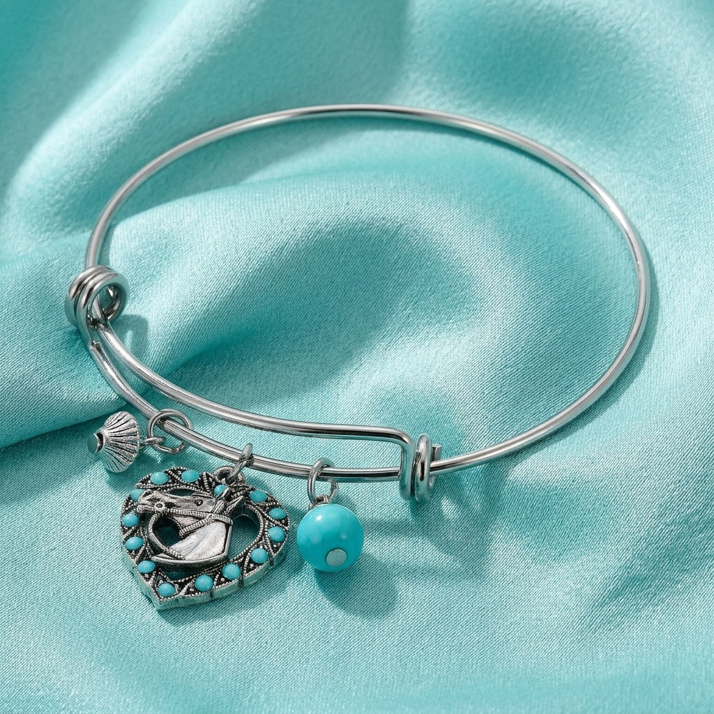 Silver bracelet with equestrian charms on a turquoise fabric background