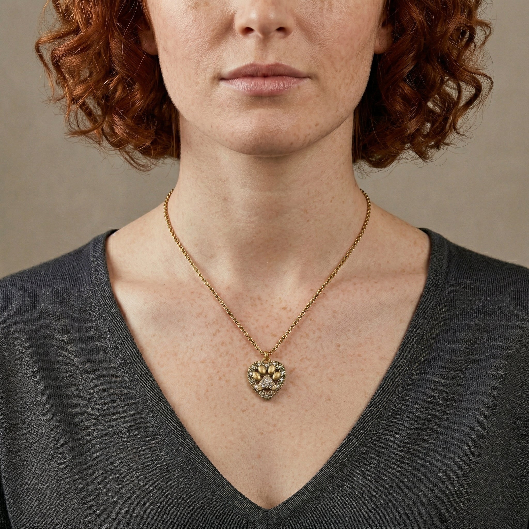 Person wearing Heart And Paw Crystal Accent Pendant Necklace against a neutral background