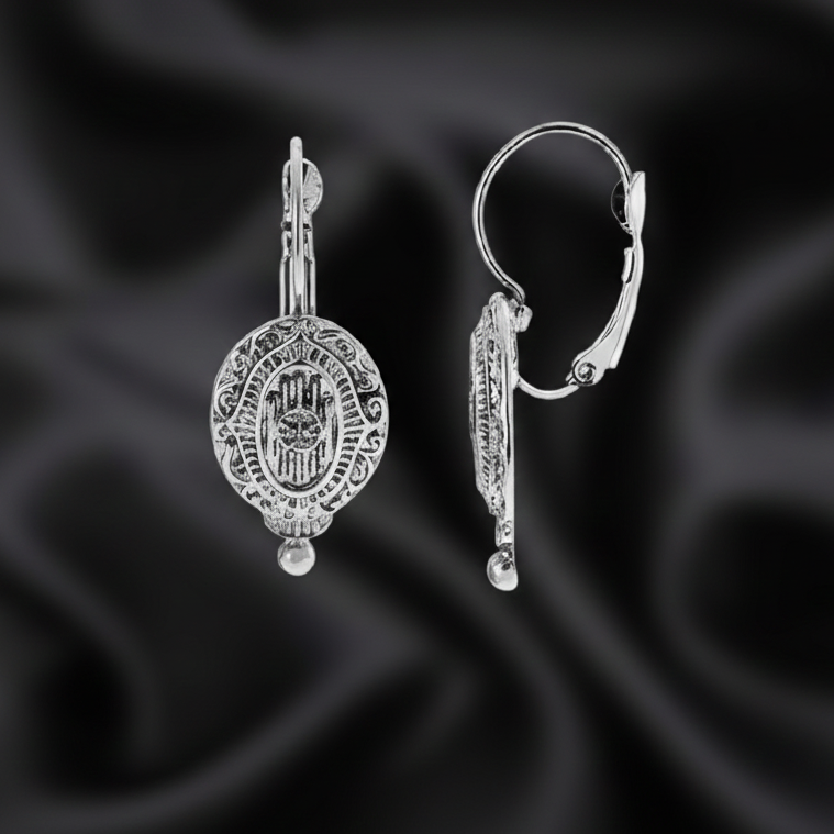 Silver earrings on a black satin background