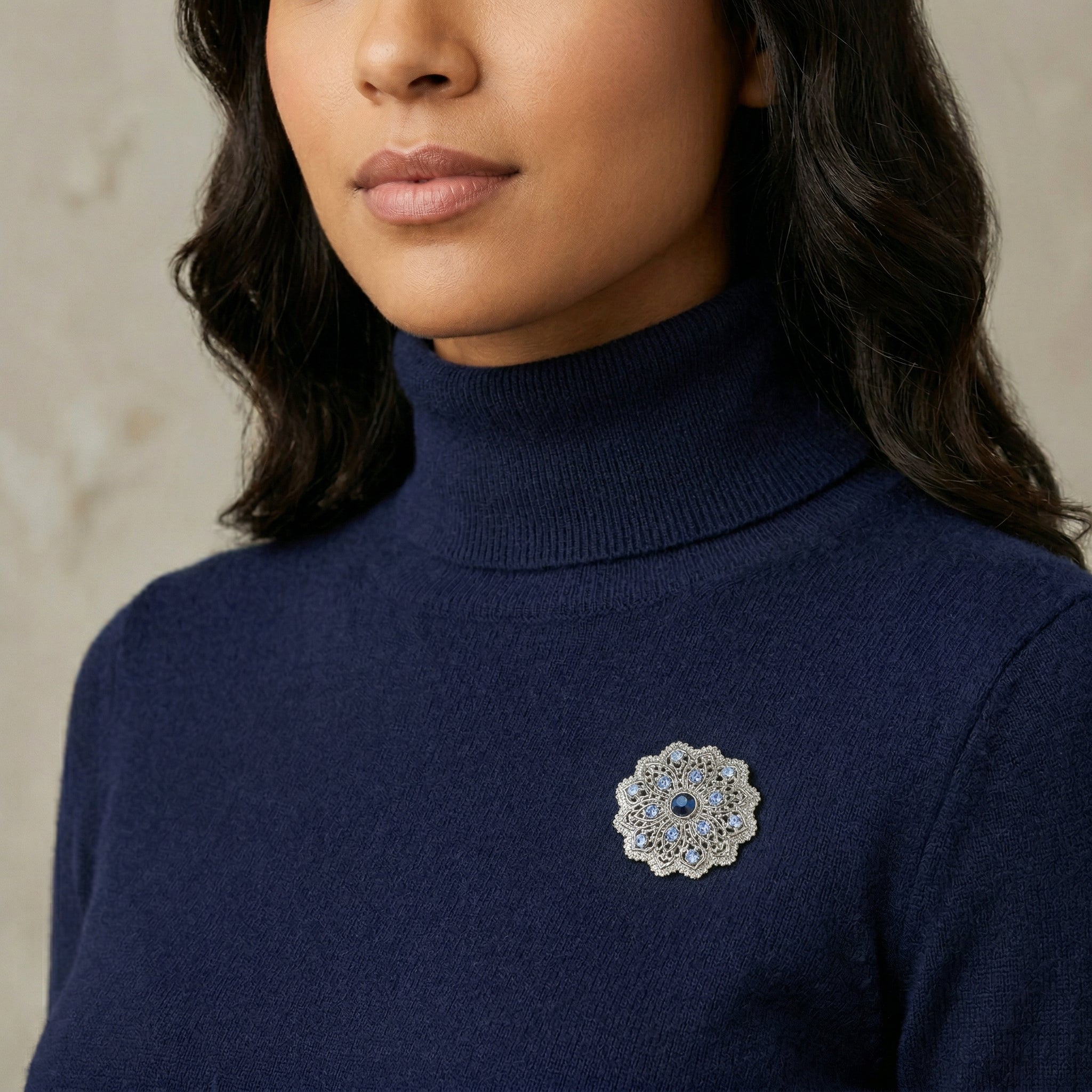 Woman in a navy blue turtleneck wearing Imperial Silver Tone Flower Blue Crystal Brooch