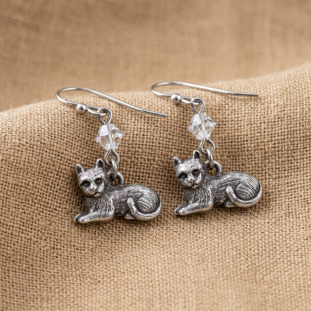 Pewter Cat & Austrian Crystal Bead Drop Earrings resting on tan colored linen