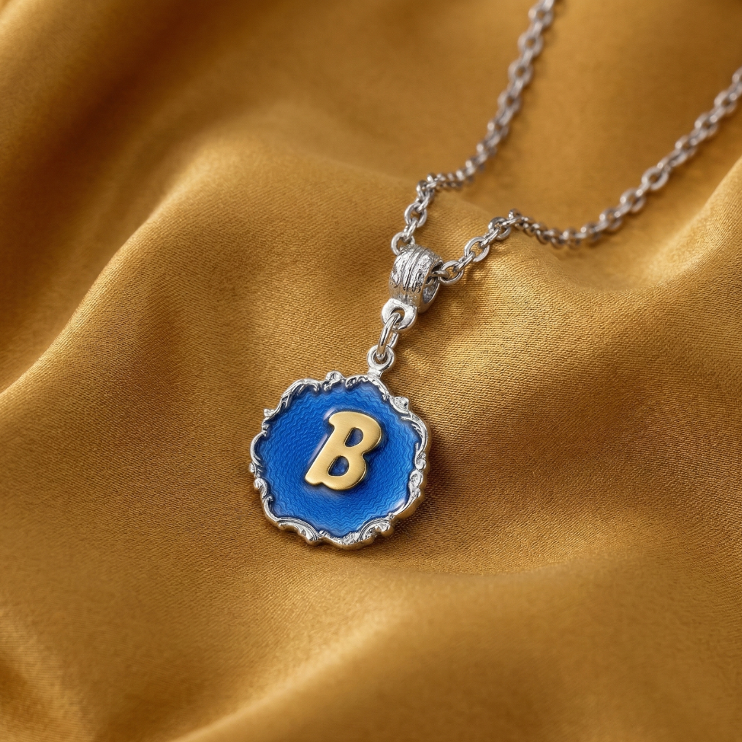 Necklace with a blue pendant featuring the letter 'B' on a gold fabric background