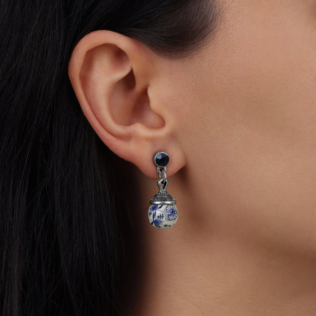 A close-up of a person's ear wearing Blue Willow Round Beaded Post Drop Earrings