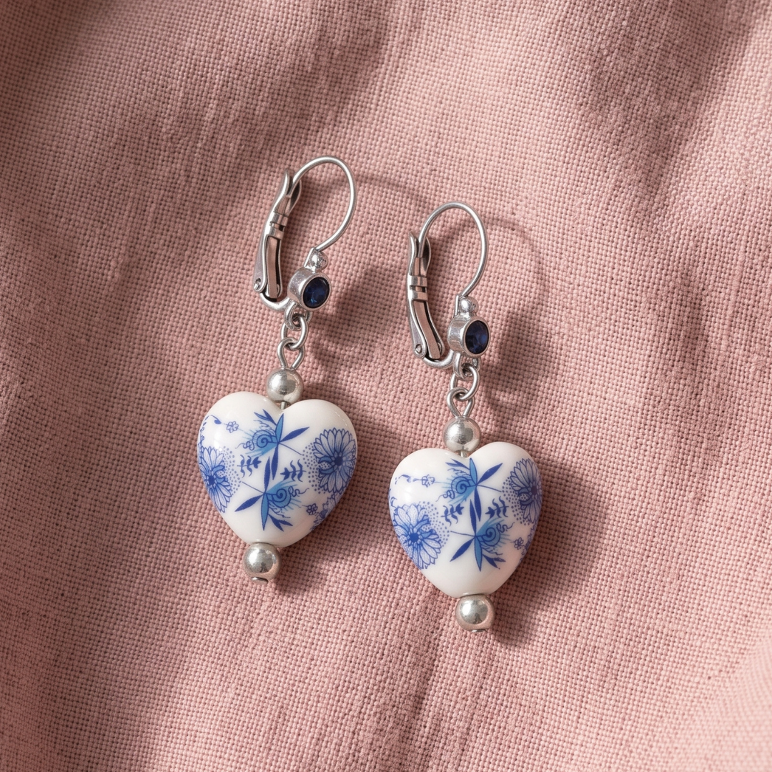 Blue Willow Blue Stone Heart Drop Earrings resting on light pink linen fabric