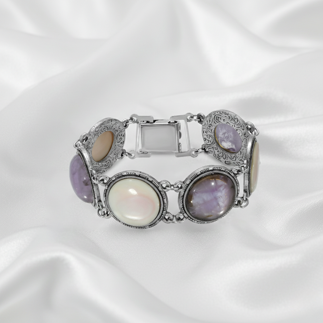 Silver bracelet with round stones on a white satin background.