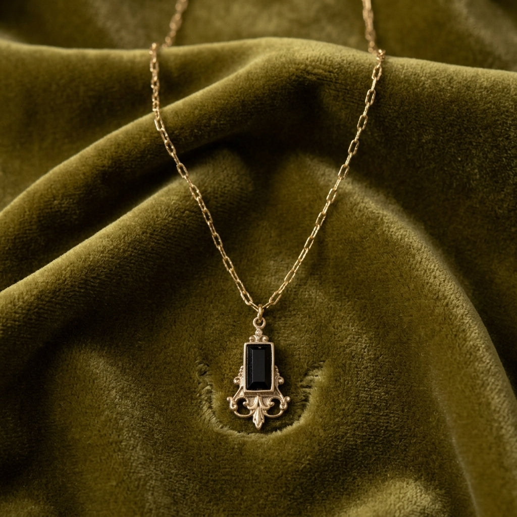 Classical Jet Black Baguette Stone Pendant necklace resting on yellowish green fabric
