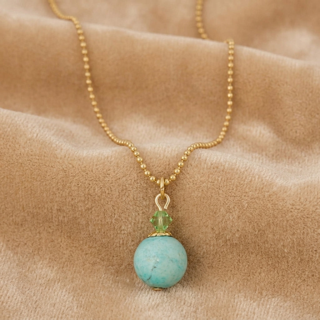 Turquoise Gemstone Round Beaded Drop Necklace on a beige fabric surface