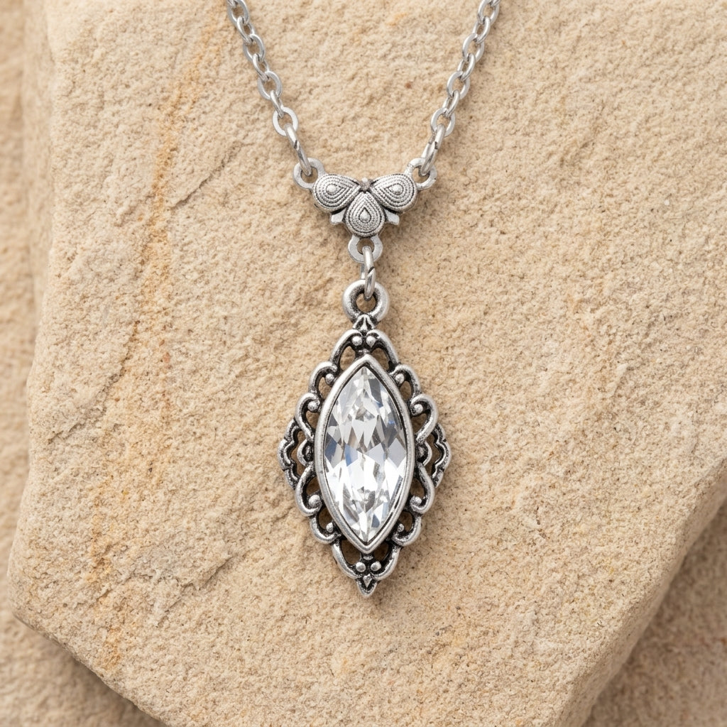 Navette Crystal Antiqued Drop Necklace resting on light stone surface