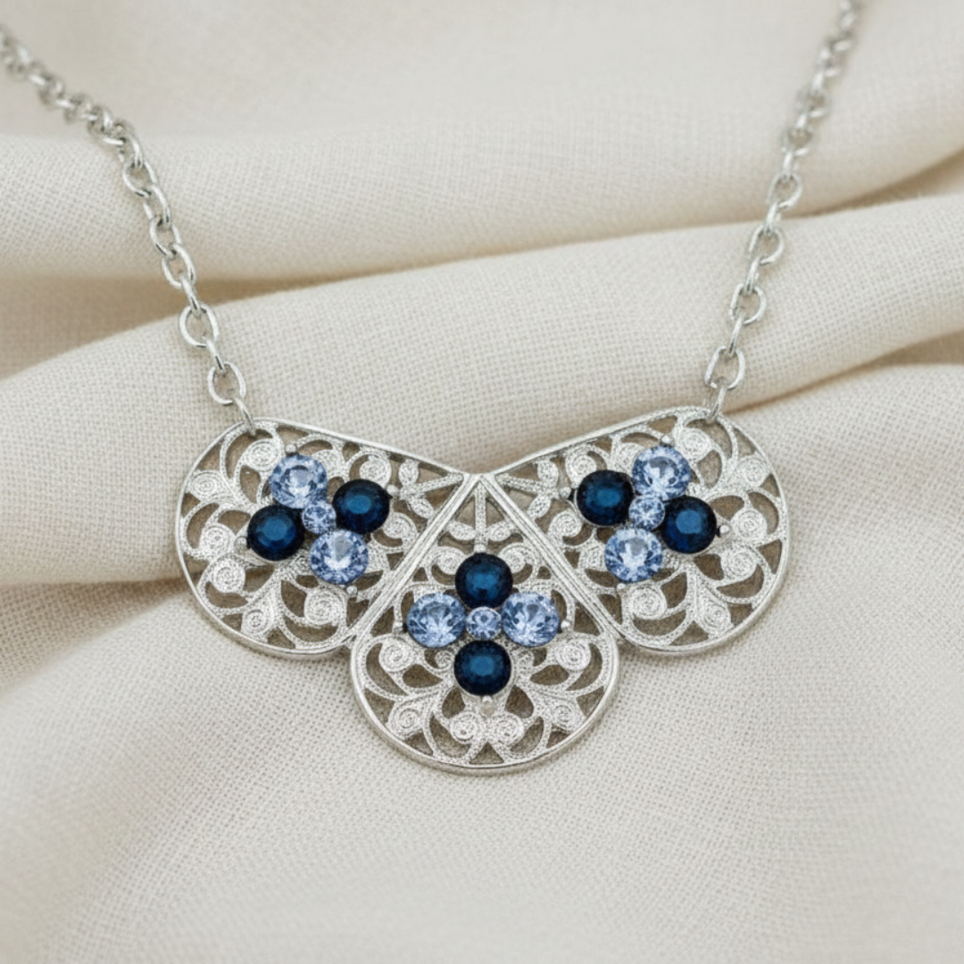Silver necklace with blue gemstones on a beige fabric background