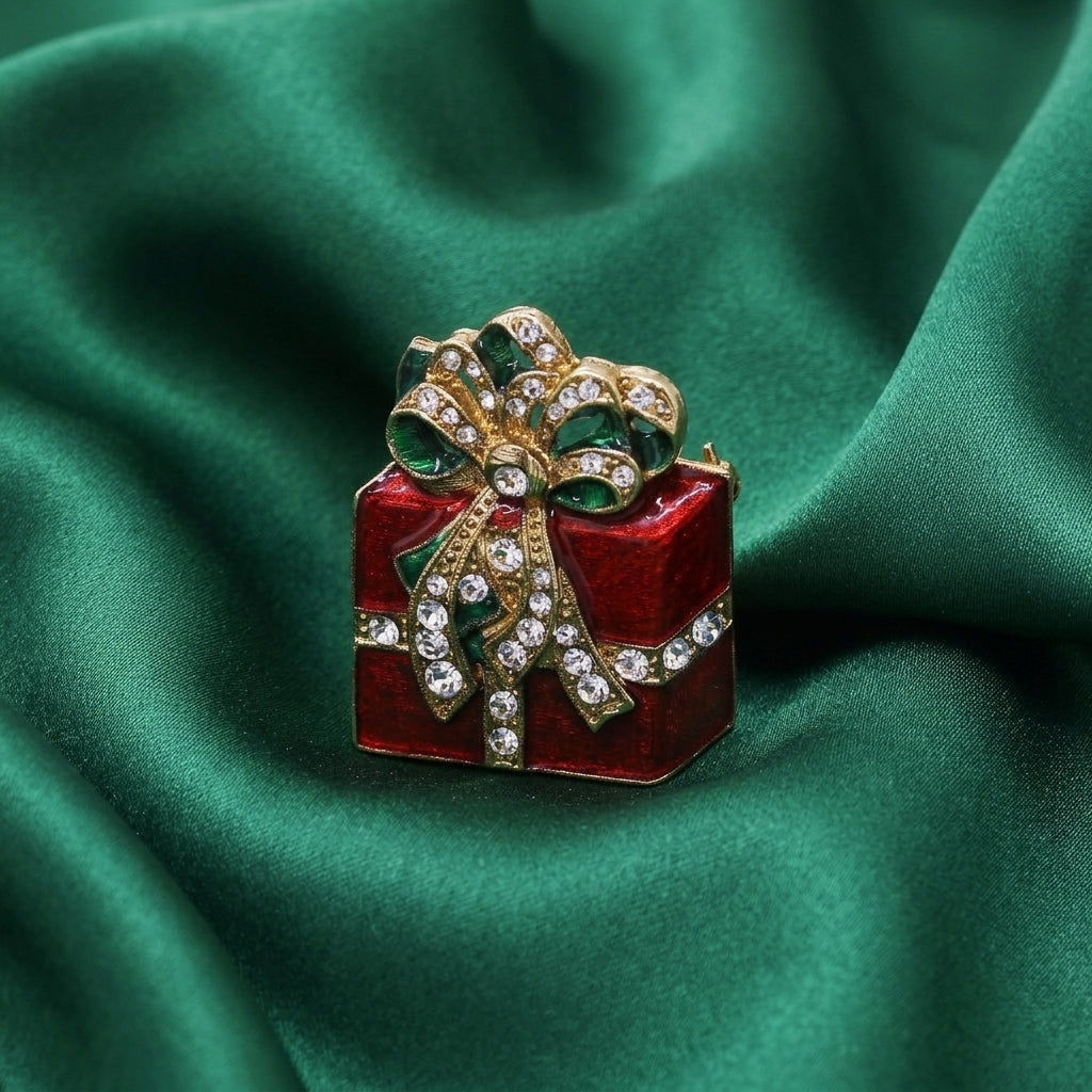 Red Christmas Present Crystal Gift Box Brooch Pin resting on dark green satin fabric