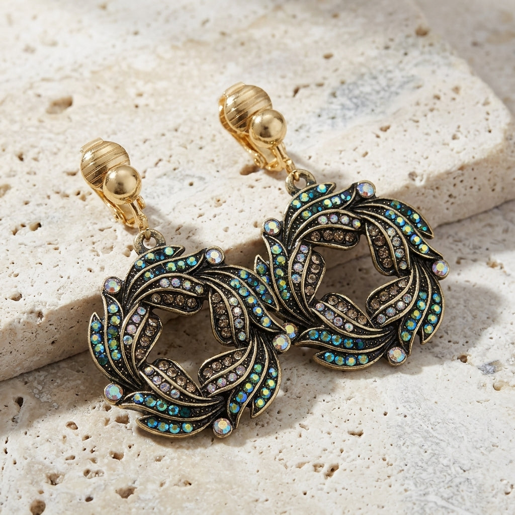 Peacock Plumage Art Nouveau Style Blue Iridescent AB Glass Wreath Clip On Earrings on a textured stone surface