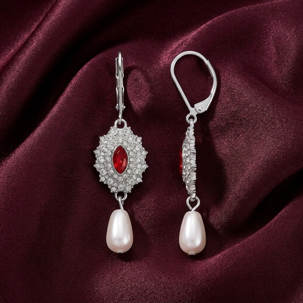 Siam Red Starburst Crystal Pearl Dangle Earrings on a burgundy fabric background