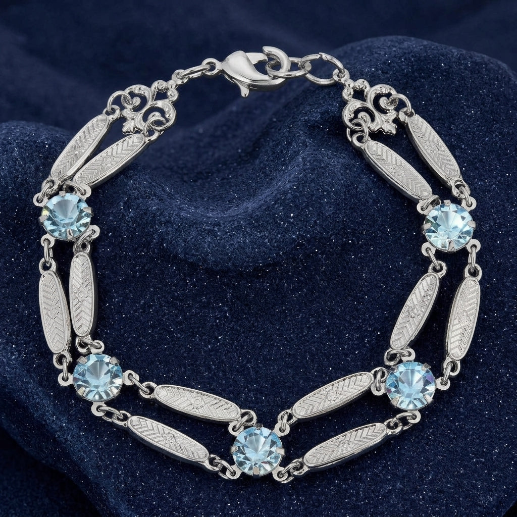 Silver tone bracelet with light sapphire blue Austrian crystals resting on a sparkling dark blue stone surface