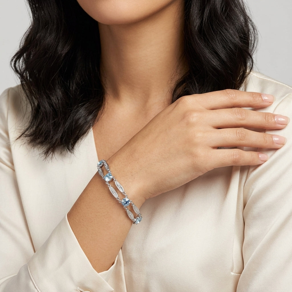 Woman wearing a silver tone bracelet with light sapphire blue Austrian crystals on her wrist