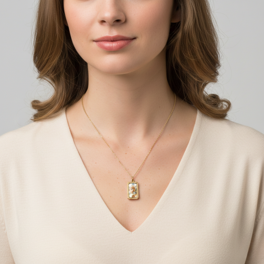 Woman wearing a gold necklace with a floral portrait pendant against a neutral background