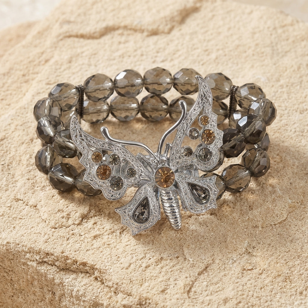 Bracelet with butterfly design and beaded texture on a beige surface
