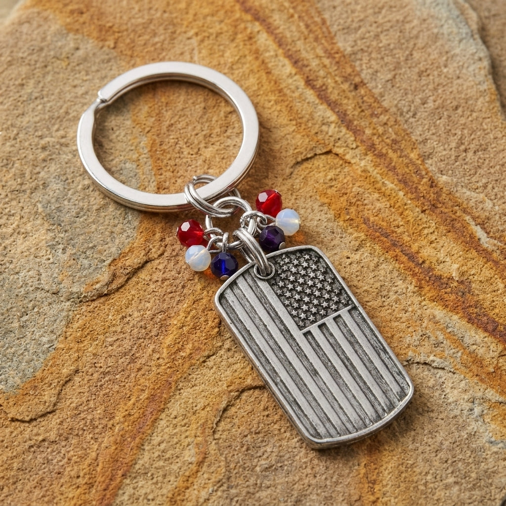 American flag keychain with red, white, and blue beaded charms on a textured stone surface