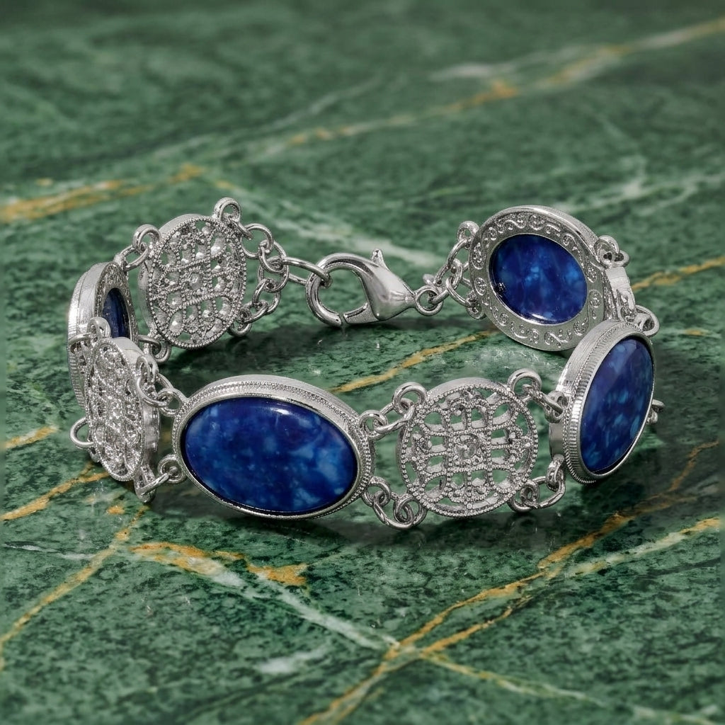 Silver bracelet with blue stones on a green marble surface