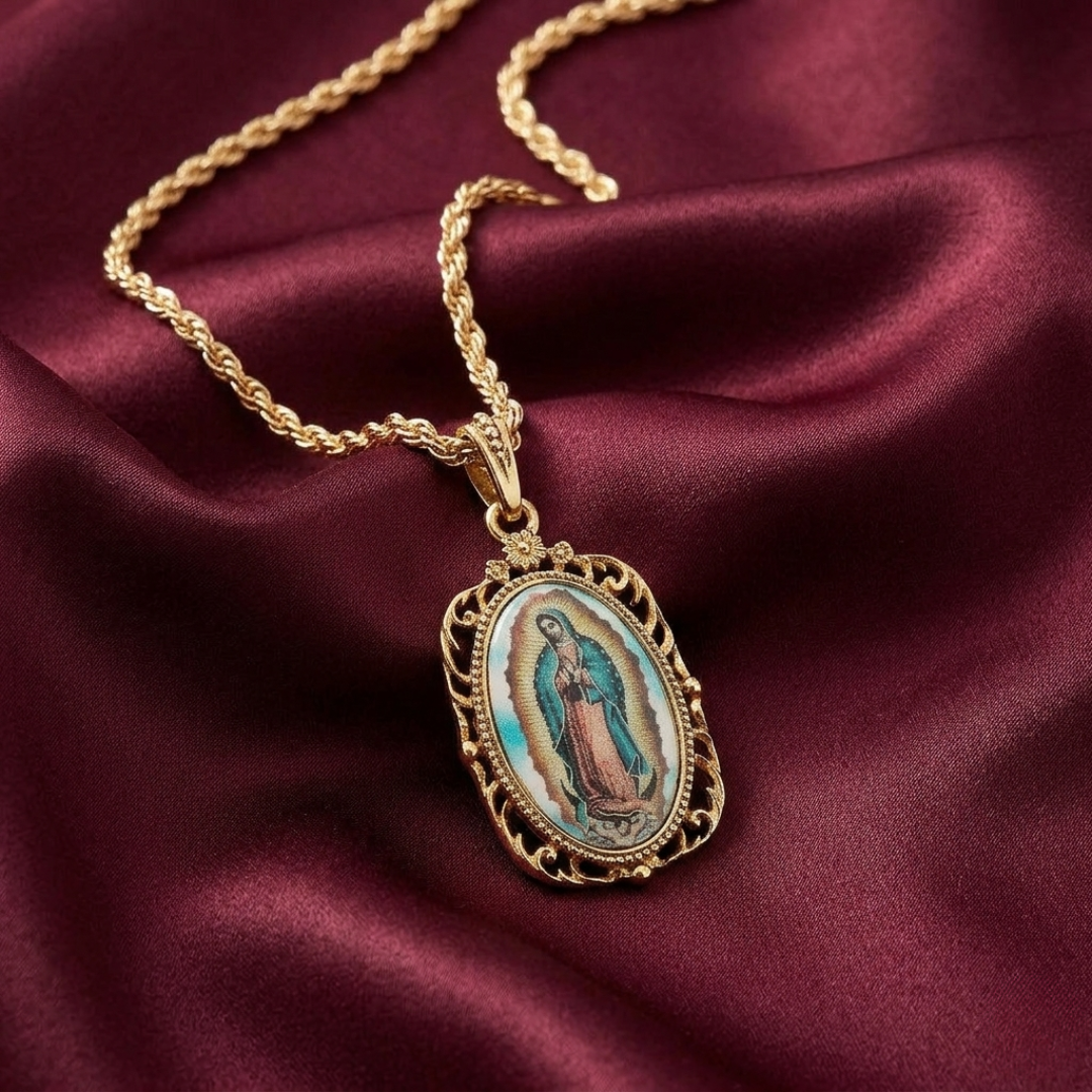 Gold necklace with a religious Lady of Guadalupe pendant on a maroon fabric background