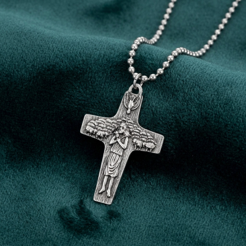 Silver cross pendant necklace on a green fabric background