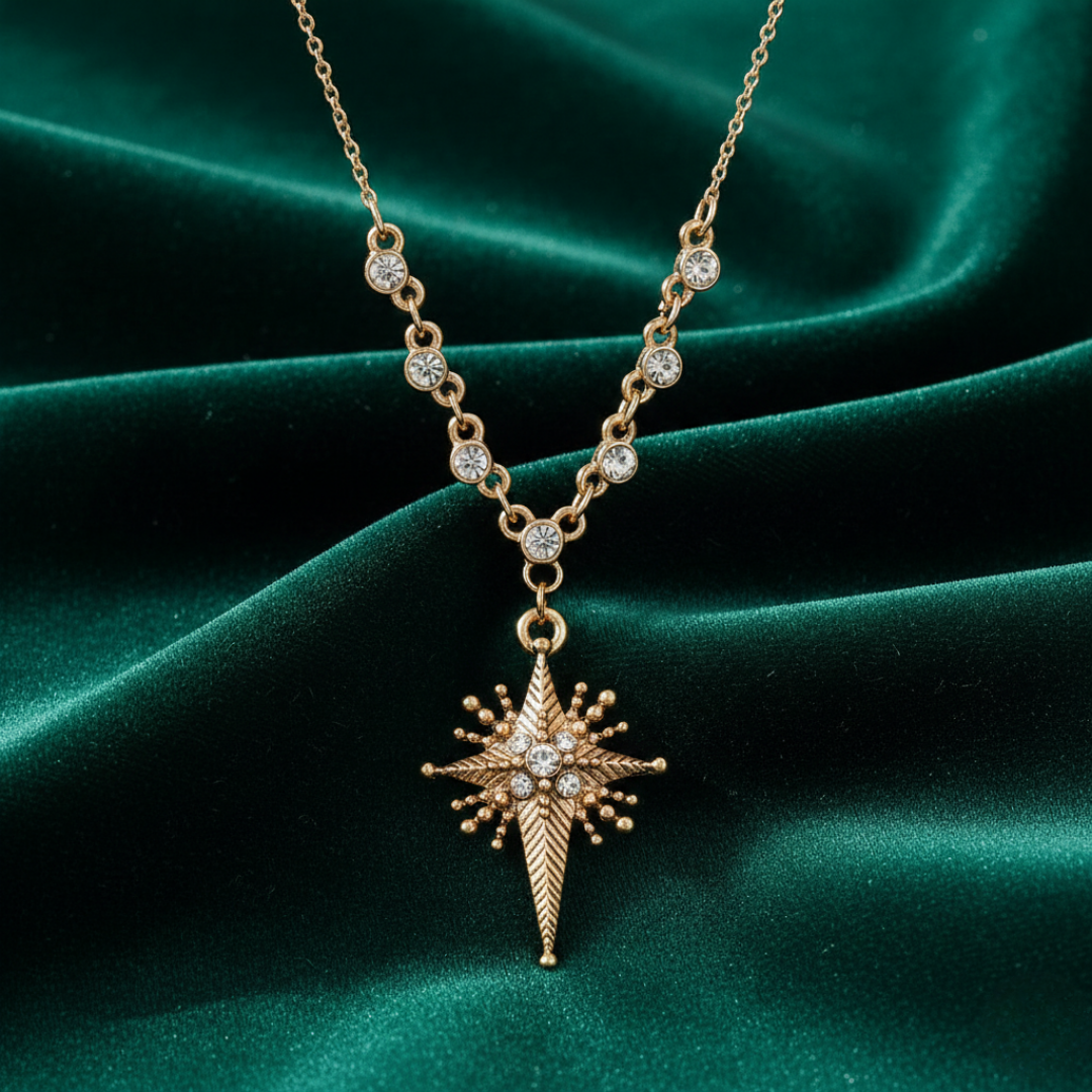 Gold necklace with a star-shaped cross pendant on a green satin background