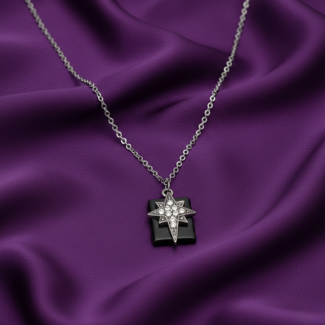 Necklace with a star-shaped cross pendant on a purple fabric background