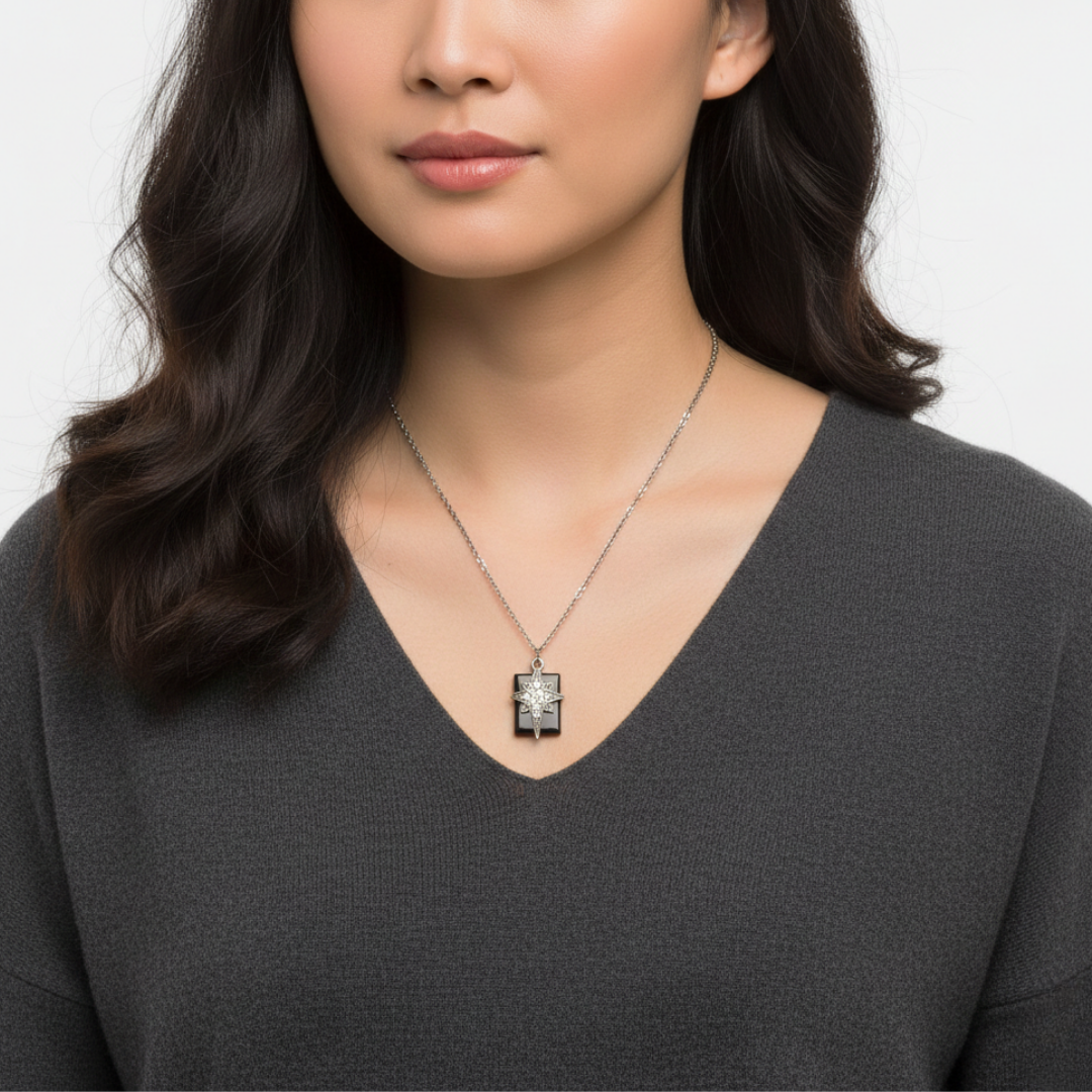 Woman wearing a necklace with a radiant cross star pendant against a neutral background