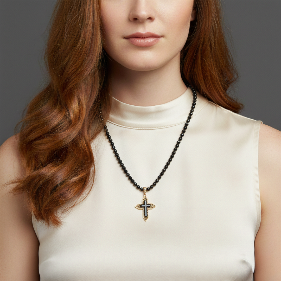 Woman wearing a necklace with a cross pendant against a neutral background