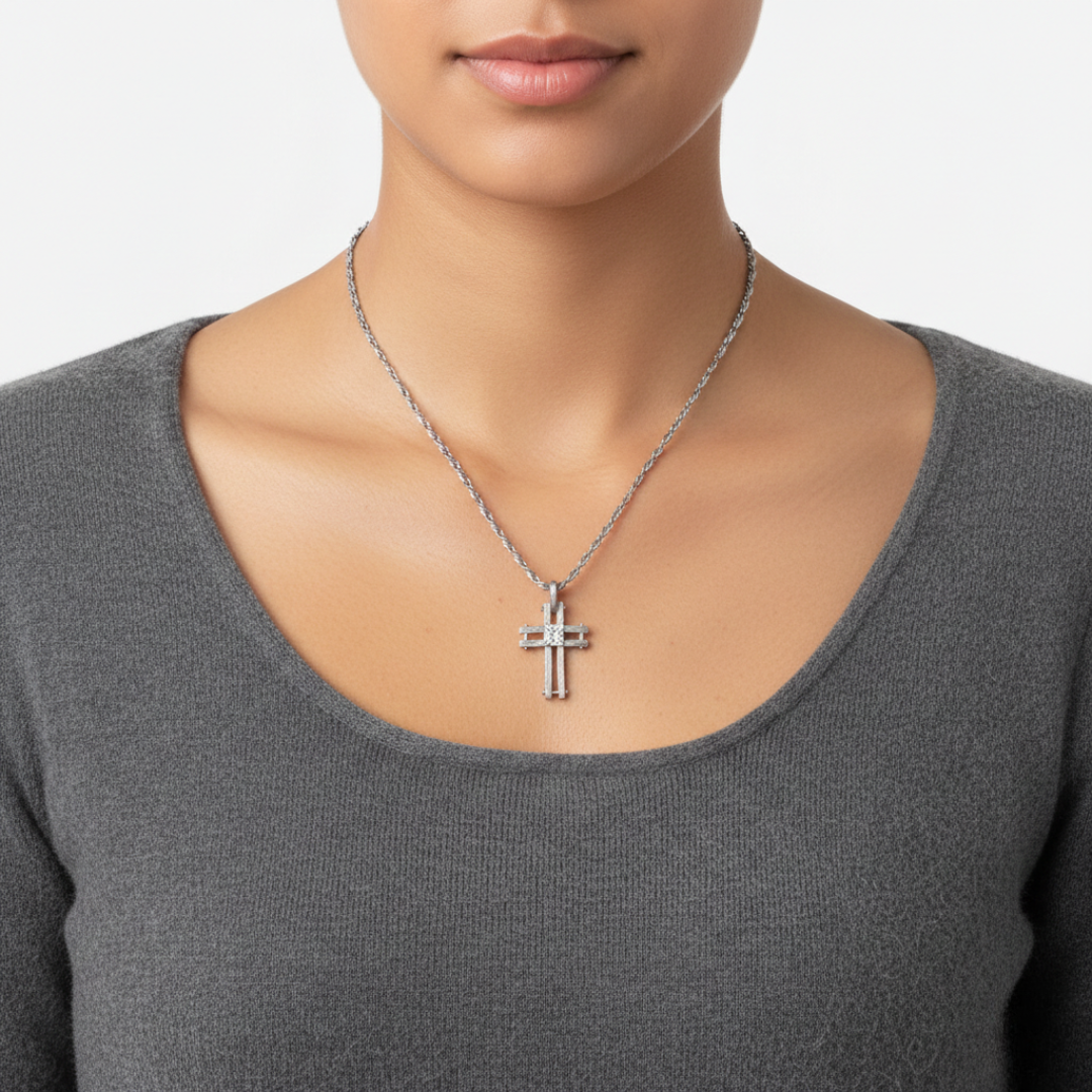 Person wearing a silver cross necklace on a plain background