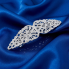Silver decorative barrette on blue satin fabric