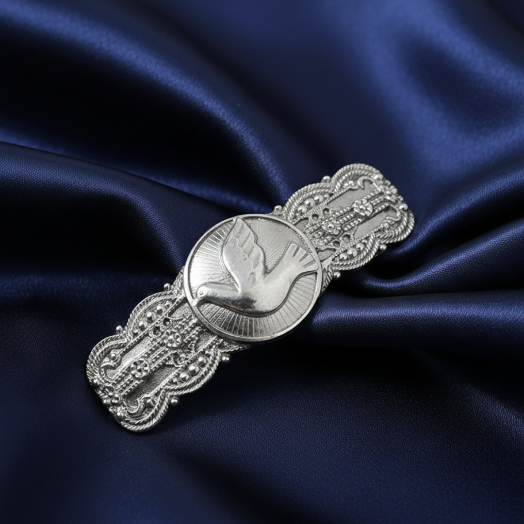 Silver brooch on a dark blue satin background.