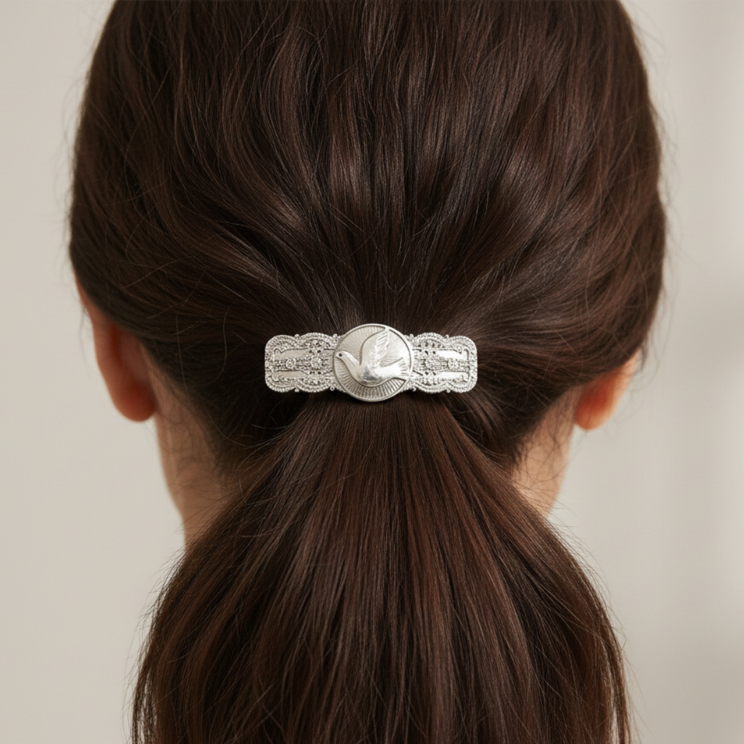 Hair barrette with decorative clasp in a ponytail against a neutral background.