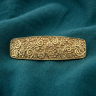 Gold Floral Hair Barrette on a teal fabric background