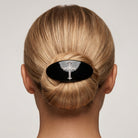 Blonde woman with her hair in a bun wearing a Oval Jet Black Pewter Crystal Cross Hair Barrette