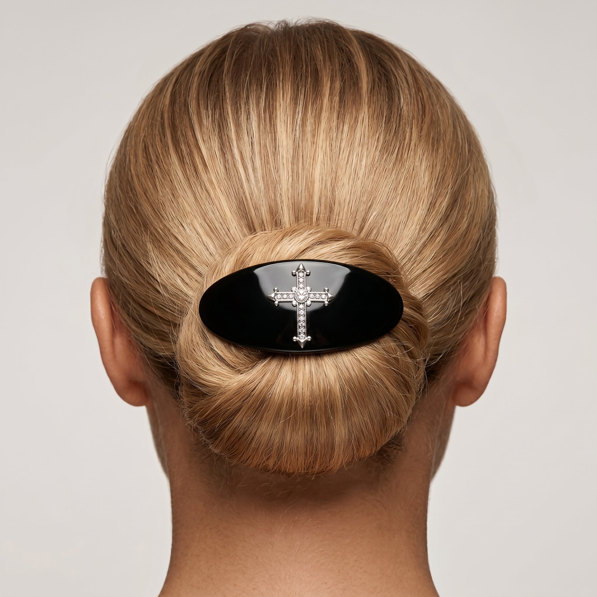 Blonde woman with her hair in a bun wearing a Oval Jet Black Pewter Crystal Cross Hair Barrette