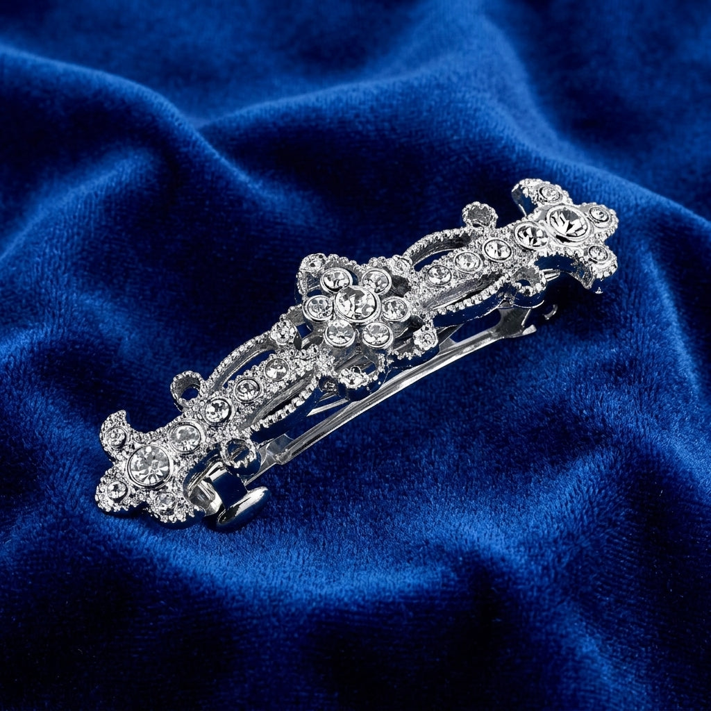 Decorative silver hair clip with crystals on a blue velvet background