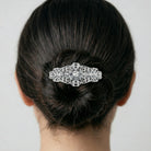 Opulent Filigree Round Crystal Bar Hair Barrette in a woman's hair bun on a plain background