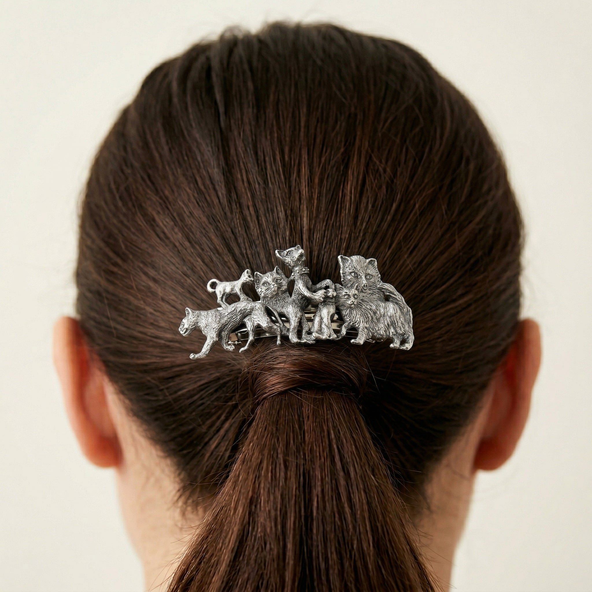 Silver tone Cat Clique Hair Barrette on a person's hair against a plain background