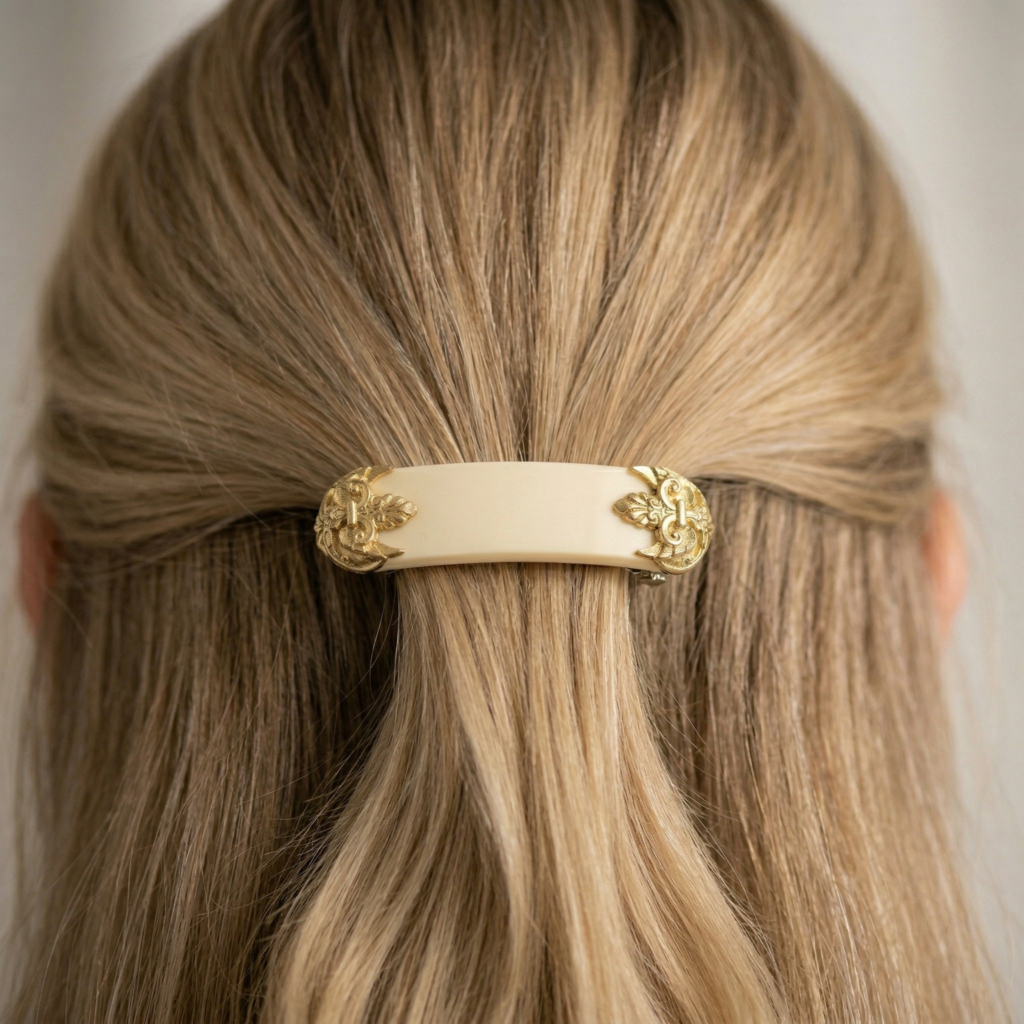 Close-up of a Oval Ivory Fleur de Lis Hair Barrette in a woman's hair