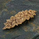 Gold floral barrette on a dark stone surface