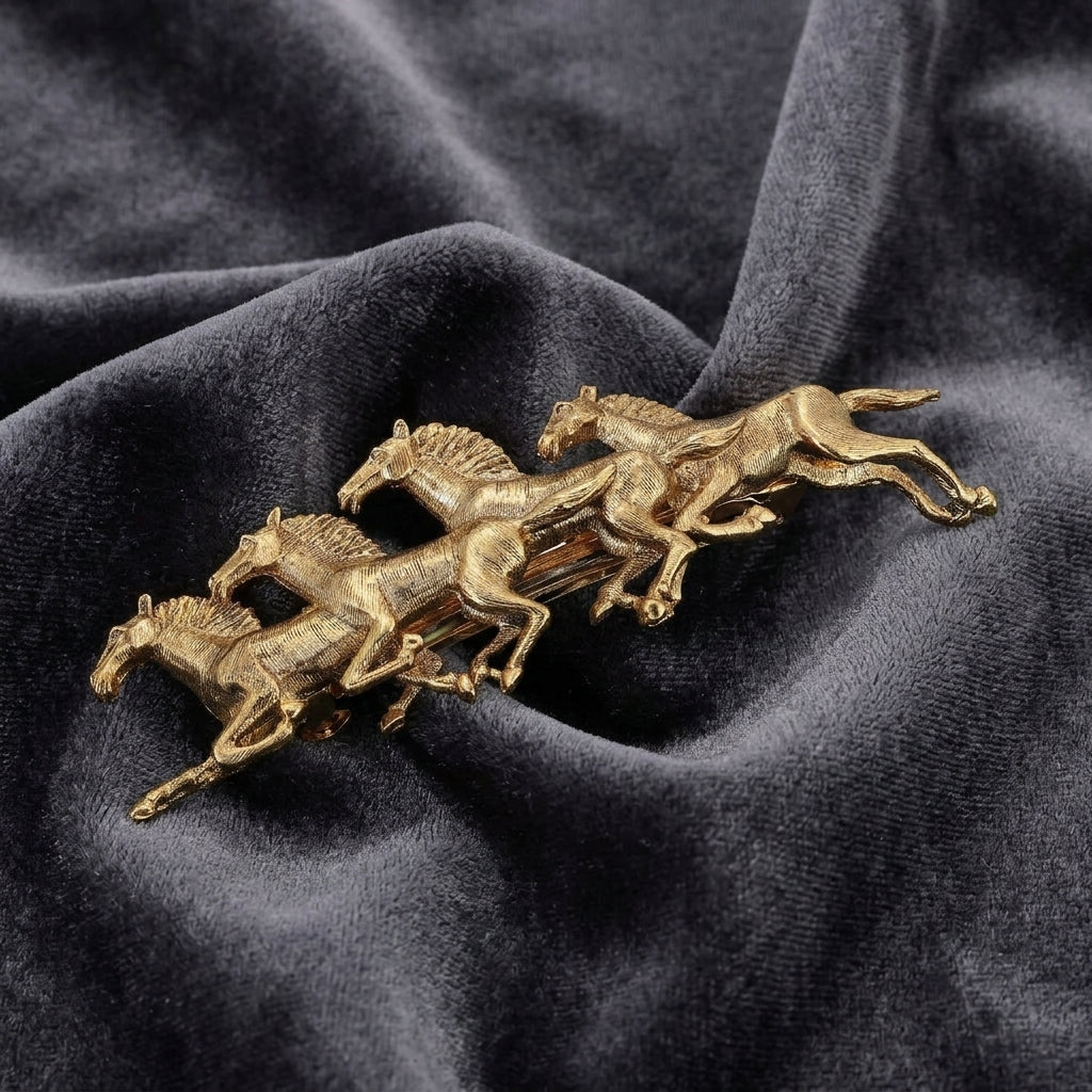Gold horse-shaped barrette on a dark fabric background