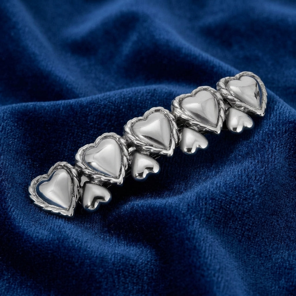 Silver Polished Hearts Hair Barrette on a blue fabric background